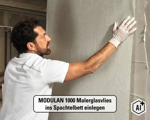 Ein Mann legt MODULAN 1000 Malerglasvlies in ein frisches Spachtelbett an einer Wand ein. (Image AI modified or generated)