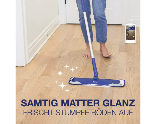Eine Person wischt einen Parkettboden mit einem Bona Wischmopp, ergänzt durch Bona Parkettpflege in einer Flasche.