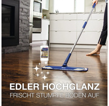 Person reinigt einen Holzboden mit einem Bona Bodenwischer und einem Bona Parkett Polish in einer modernen Küche.