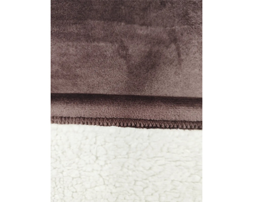 Nahaufnahme einer Kuscheldecke mit einer weichen, plüschigen Oberfläche und einer gefütterten Rückseite in Lammfelloptik mit genähter Kante