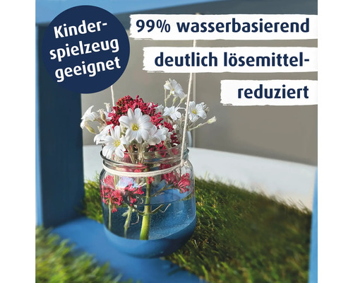 Ein Glas mit Blumen steht auf einer Rasenflaeche. Text informiert ueber Kinderspielzeugseignung, Wasserbasis und loesemittelreduzierte Rezeptur.