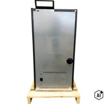 Rückseite eines Pelletkaminofens auf einer Holzpalette mit Tragegriff und Belüftungsschlitzen. (Image AI modified or generated)