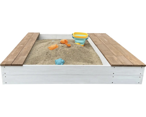 Ein Sandkasten aus Holz mit weißen Seitenwänden und hölzernen Sitzflächen, gefüllt mit Sand und Spielzeug.