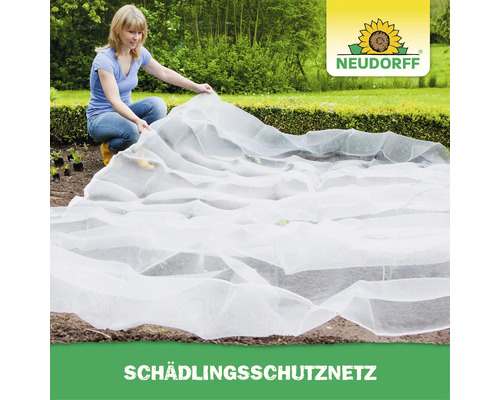 Eine Frau deckt ein Beet mit einem weißen Neudorff Schädlingsschutznetz ab, um ihre Pflanzen vor Insekten zu schützen.