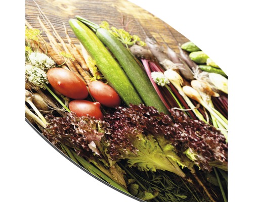 Frisches Gemüse auf einem Schneidebrett: Zucchini, Tomaten, Salat und Karotten.