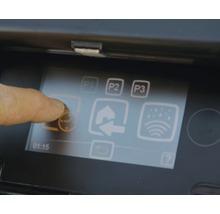 Nahaufnahme eines Bildschirms mit einer Fingerberührung auf einem Symbol für eine Bewässerungsuhr.