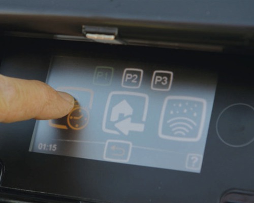 Nahaufnahme eines Bildschirms mit einer Fingerberührung auf einem Symbol für eine Bewässerungsuhr.