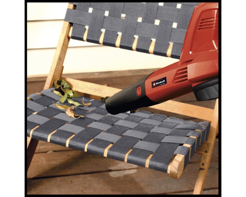 Einhell Laubbläser im Einsatz, um Blätter von einem Holzstuhl zu entfernen