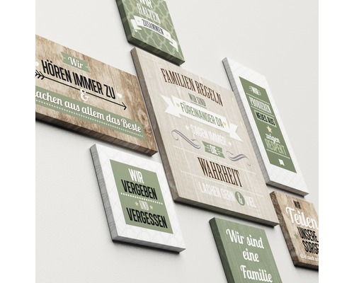 Dekorative Wandbilder mit Familiensprüchen gestalten eine helle Wand.