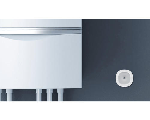 Weißer Heizkessel mit Rauchmelder an der Wand