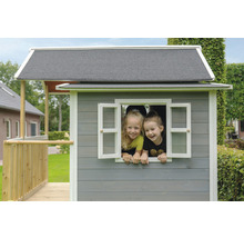 Zwei Kinder schauen aus dem Fenster eines Spielhauses aus Holz.
