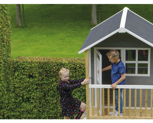 Spielhaus aus Holz mit zwei Kindern im Garten.