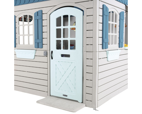 Detailansicht eines Spielhauses mit Tür, Fenstern und Fensterläden.