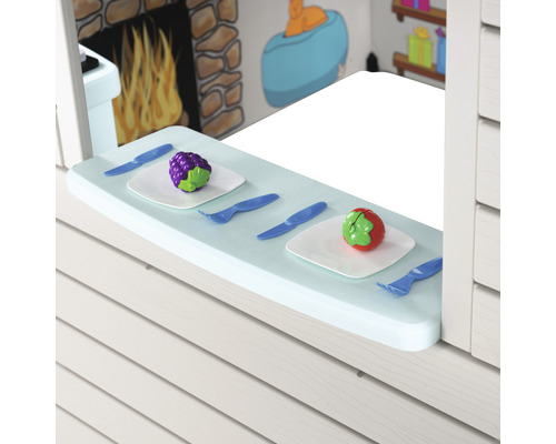 Spielküchen-Szene mit Spielzeugobst, Tellern und Besteck auf einer Fensterbank