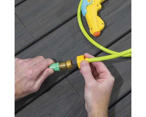 Zwei Hände verbinden einen Gartenschlauchanschluss mit einem Gartenschlauch