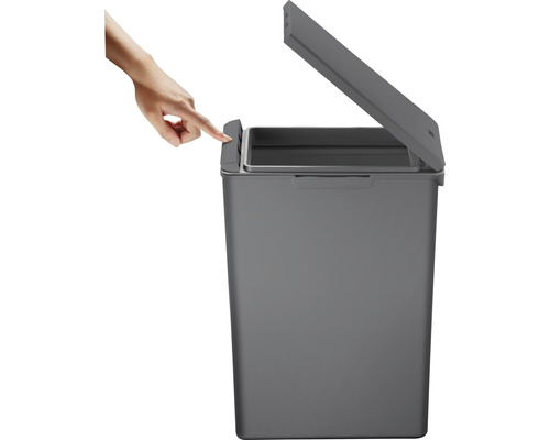 Grauer Abfallbehälter mit geöffnetem Deckel, der per Hand bedient wird