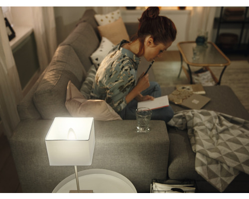Wohnzimmerszene mit Lampe und Frau auf Sofa