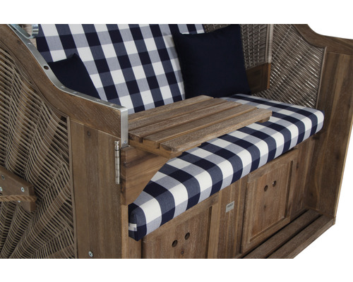 Strandkorb mit karierten Kissen und Holztisch