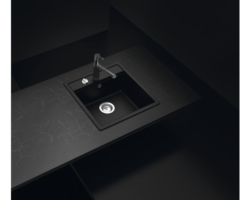 Schwarzes Spülbecken mit Wasserhahn auf einer Arbeitsplatte