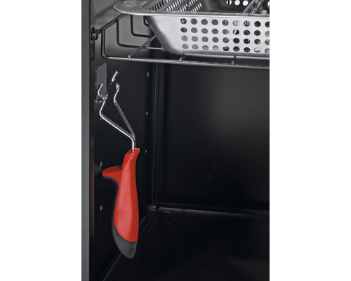 Innenraum eines Grills mit Grillzange und Abtropfschale