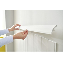 Person befestigt weiße Wandpaneele an der Wand