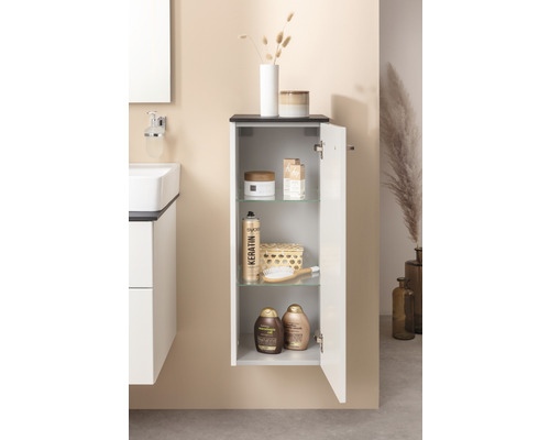 Badezimmer mit Hängeschrank, Waschbecken und diversen Badutensilien.