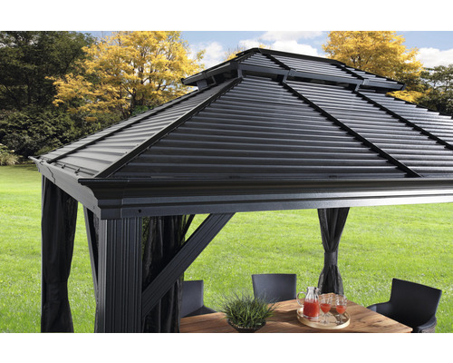 Detailansicht eines Pavillons mit Metalldach, Vorhängen und Gartentisch auf einer Rasenfläche.