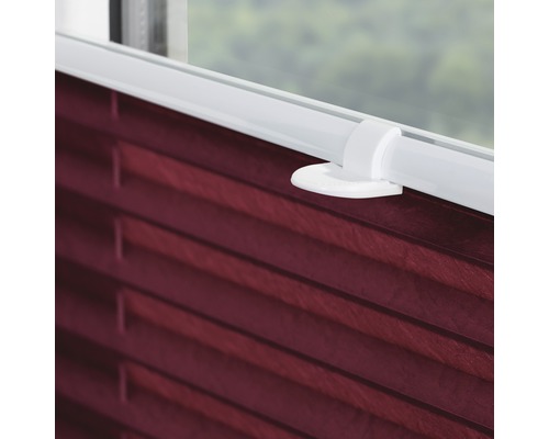 Nahaufnahme einer roten Plissee-Jalousie am Fenster mit Bedienelement