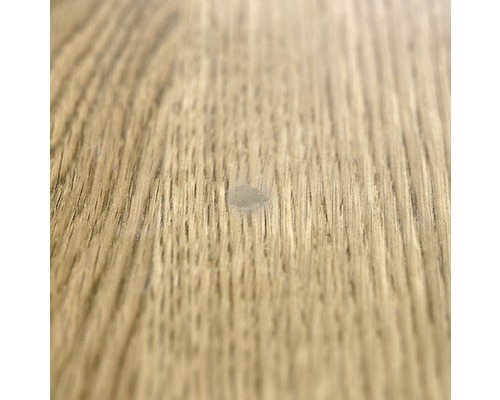 Nahaufnahme eines Laminatbodens mit einer kleinen Beschädigung