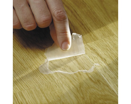 Abziehen einer Schutzfolie von einem Holzfußboden