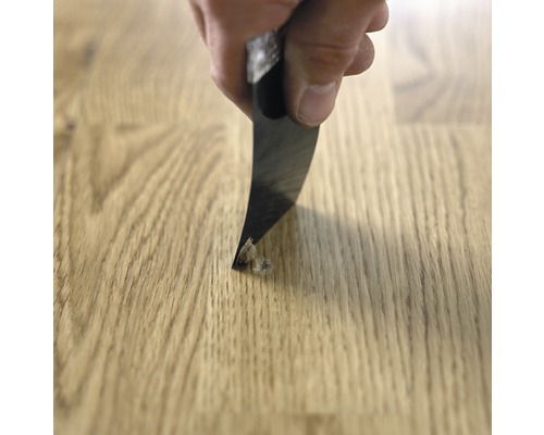 Hand entfernt beschädigten Bereich von Parkett mit Stecheisen