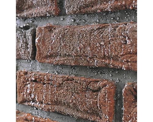 Nahaufnahme einer Ziegelwand mit Wassertropfen