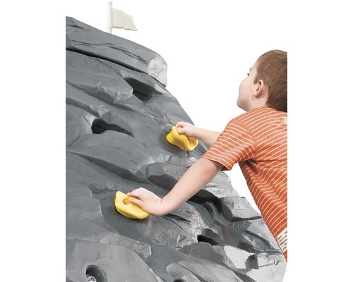 Junge klettert an Kletterwand mit Klettergriffen