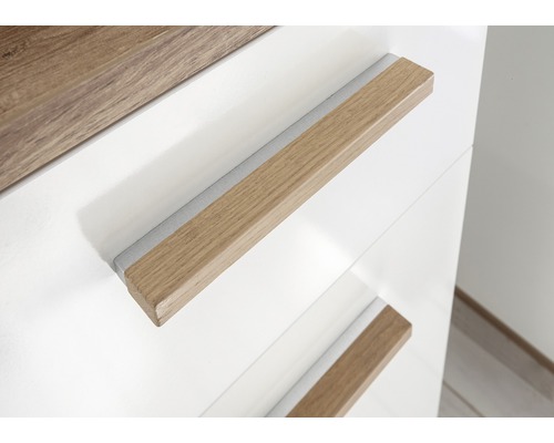 Detailaufnahme eines weißen Schranks mit Holzgriffen.