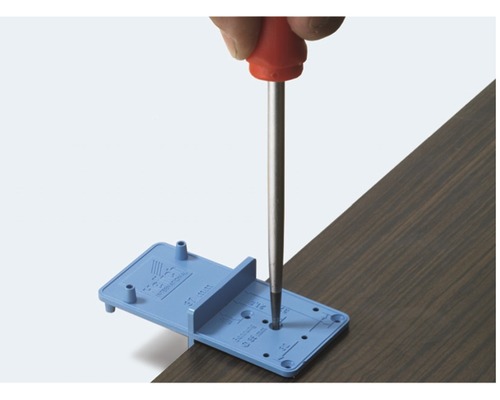 Werkzeug zur präzisen Bohrung von Löchern in Holzplatten mit Schraubendreher.
