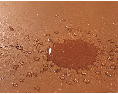 Wasser tropft auf eine wasserabweisende Oberfläche