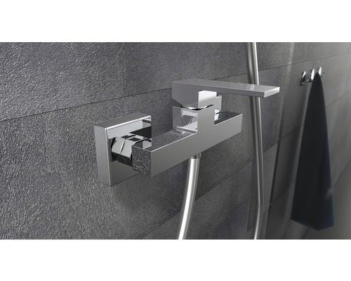 Eingebaute Duscharmatur mit Brauseschlauch an einer grauen Wand