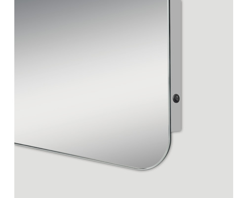 Detailansicht eines rechteckigen Spiegels mit abgerundeten Ecken und einem seitlichen Schalter