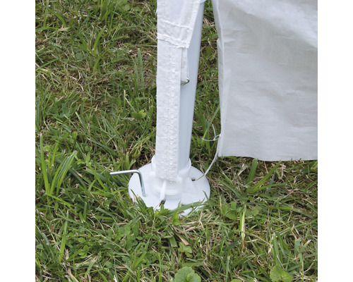 Detailansicht eines Partyzelt-Standbeins mit Heringen im Gras