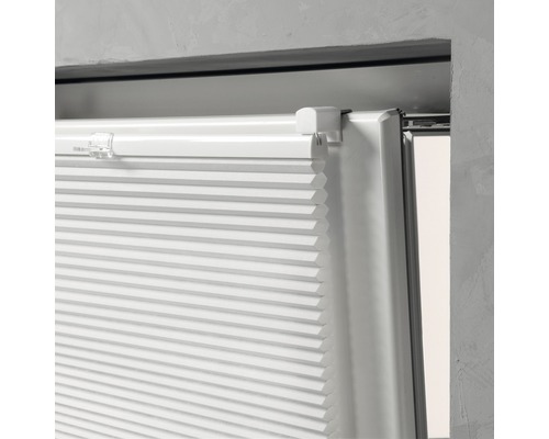 Detailansicht eines weißen Plissees am Fenster