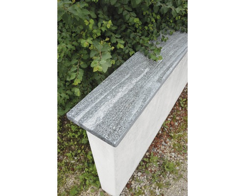 Mauerabdeckung aus Granit auf Betonmauer im Garten