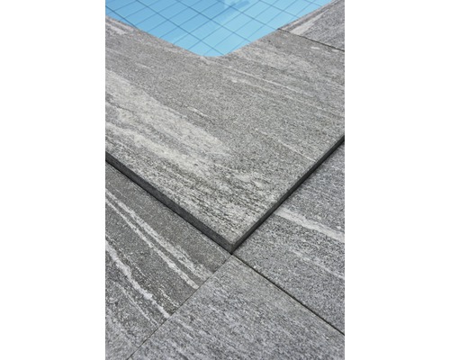 Nahaufnahme von grauen Steinplatten um einen Pool