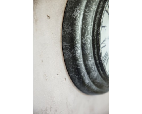 Detail einer runden Wanduhr mit römischen Ziffern