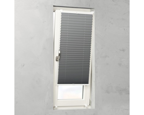Graues Faltrollo an einem Fenster zur Lichtsteuerung.
