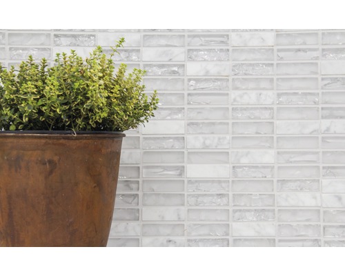 Dekorative Wand mit weißen Glasmosaikfliesen und Topfpflanze