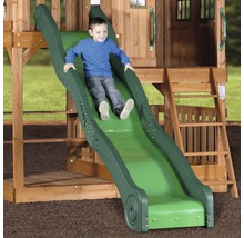 Ein Kind rutscht auf einer grünen Rutsche eines Holzspielhauses.
