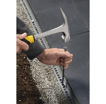 Person nagelt Rasenkante mit Hammer fest