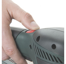 Nahaufnahme einer Hand, die einen roten Knopf an einem Elektrowerkzeug drückt.
