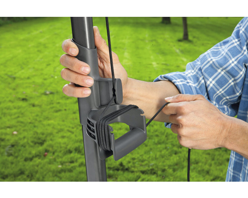 Mann befestigt Seil an Sonnenschirmständer