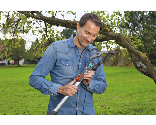 Ein Mann bedient eine Astschere im Garten.